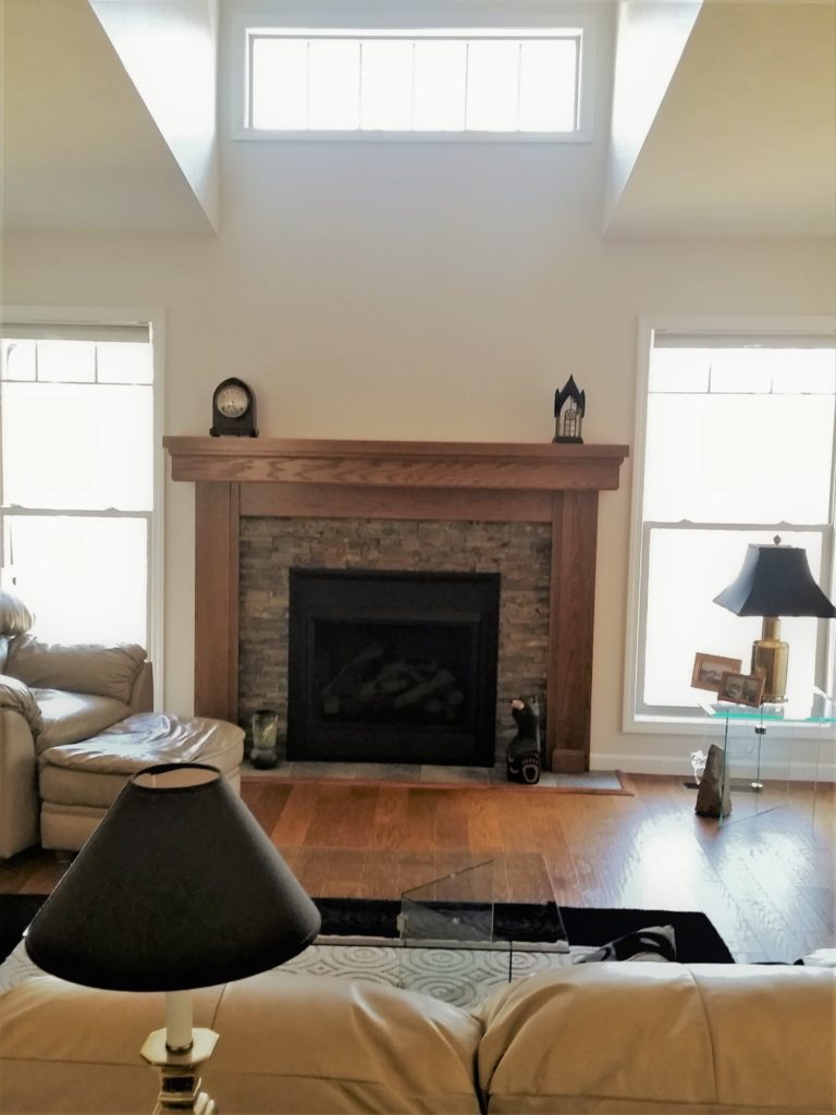 A view of the family room, fireplace, and high window.