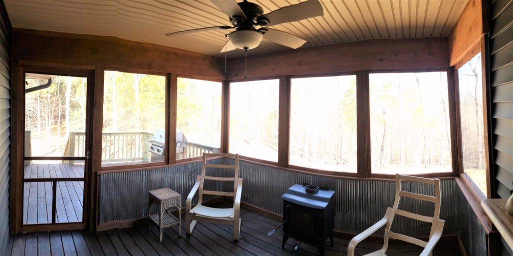 A panoramic view of the inside of the screened-in back porch.